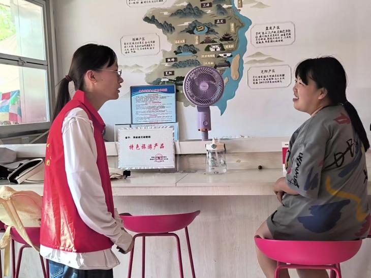 圖為花椒特產店店員向成員介紹花椒加工與合作的情況